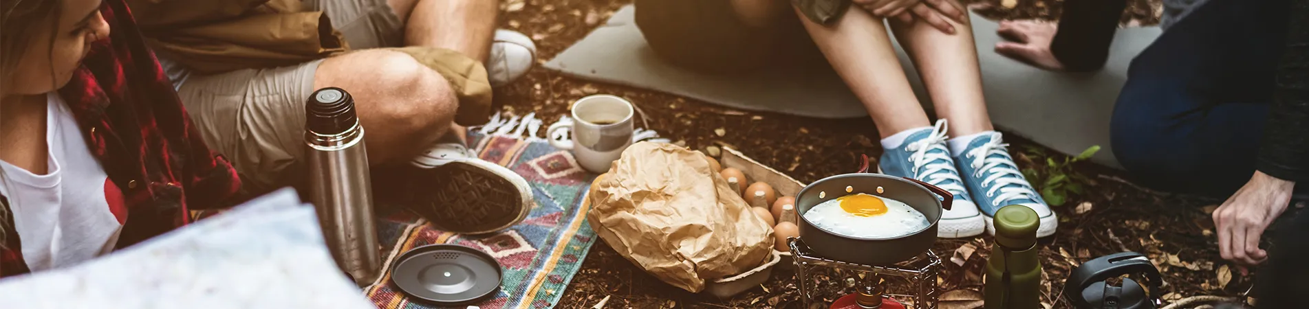 Personen sitzen auf Campingplatz