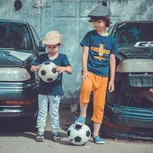 Zwei Jungen die mit Fußbällen spielen