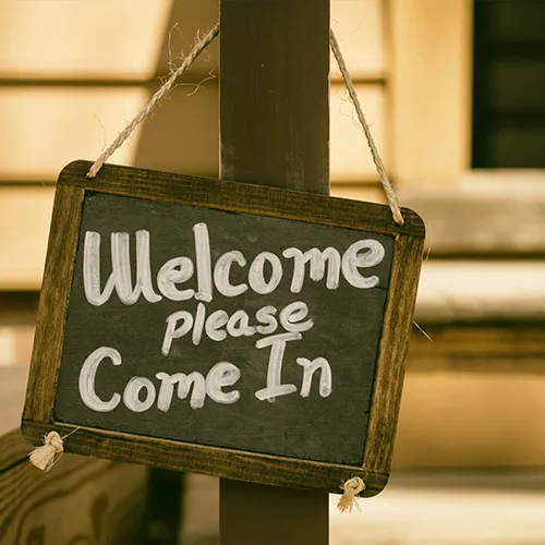 Kreidetafel mit der Aufschrift: Welcome please come in